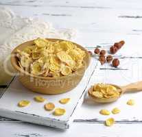 corn flakes in a wooden bowl on a white board