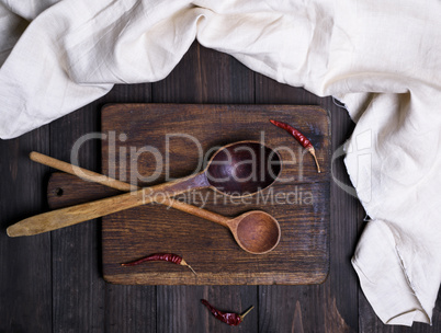 two old empty old spoons on a brown cutting board