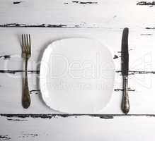 empty white ceramic plate with a fork and knife