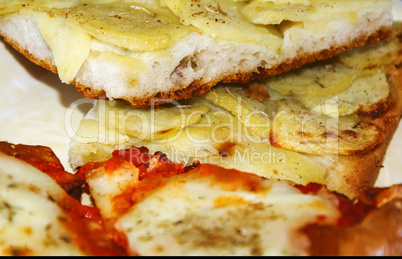 two slices of pizza with tomato, mozzarella and potatoes