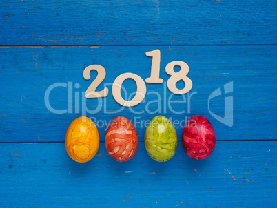 Four colorful Easter eggs on blue wood