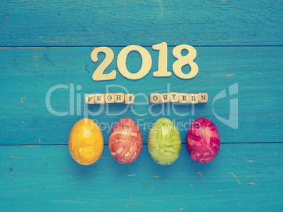 Four colorful Easter eggs on blue wood