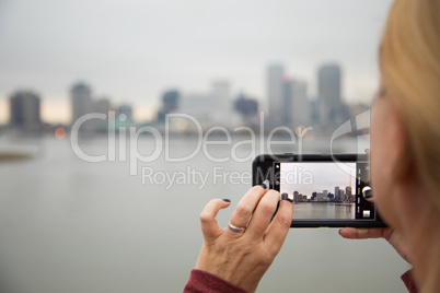 Woman Taking Pictures of The New Orleans Skyline with Her Smart
