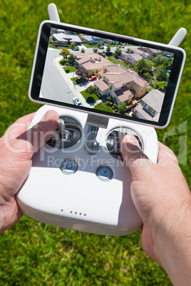 Hands Holding Drone Quadcopter Controller With Residential Homes