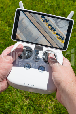 Hands Holding Drone Quadcopter Controller With Overhead of Tract