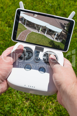Hands Holding Drone Quadcopter Controller With Overhead of House