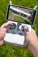 Hands Holding Drone Quadcopter Controller With Overhead of House