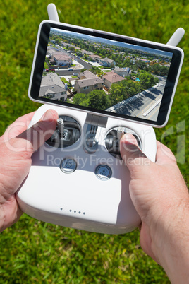 Hands Holding Drone Quadcopter Controller With Residential Homes