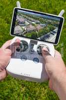 Hands Holding Drone Quadcopter Controller With Residential Homes