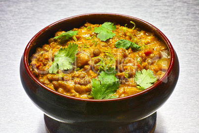 Moong Dal, indian vegetarian lentil soup in terra cotta bowl.