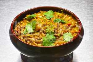 Moong Dal, indian vegetarian lentil soup in terra cotta bowl.