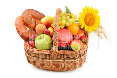 A set of fruits and pastries in a woven basket isolated on white