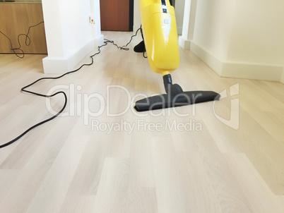 electric broom cleaning a wooden floor