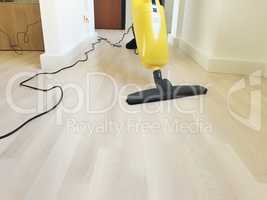 electric broom cleaning a wooden floor