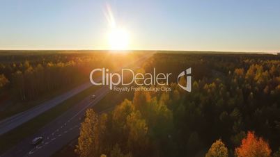 Aerial panoramic of a highway with traffic among a mixed hardwoods and conifer forest