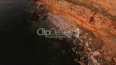 Aerial view of the precipice with terrible rocks by the sea at sunset.