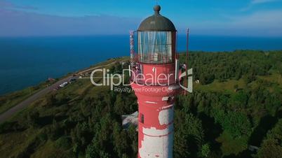 Aerial flying around an old working lighthouse with a beautiful ocean view