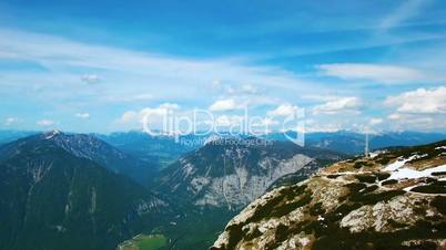 Aerial panoramic view of mountains with pine woods forest. Sun flare in summer day in Austria, Obertraun