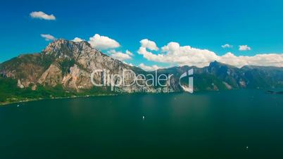 Aerial panoramic view of lake with yachts near rural area. Panoramic view with clouds and blue sky