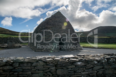 Gallarus Oratory with cloudy sky and lens flare