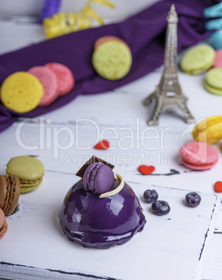 lilac round cake with macarons on a white wooden board