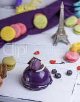 lilac round cake with macarons on a white wooden board