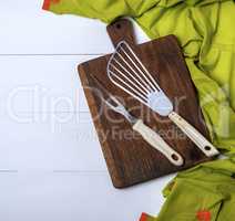 fork and scapula on a brown wooden board and green towel