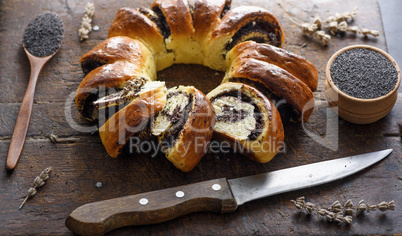 baked round pie with poppy seeds on a brown wooden cutting board