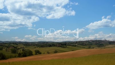 Time-lapse of cloudy sky over fields with beautiful scenic nature in the village in Italy, Tuscany