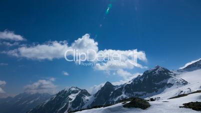 Time-lapse of clouds on the snow and cloudy mountains in Alps, Austria. In the sky flying airplane