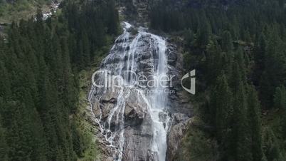 Aerial of wonderfull waterfall in the mountains with pine forest in Austian Alps