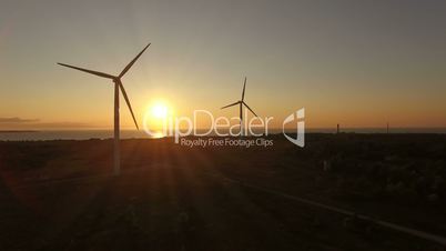 Aerial view of wind generators in the evening sky on the field. Wind generators rotate blades and extract electricity