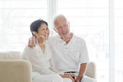 Old couple at home, looking away