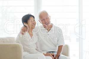 Old couple at home, looking away