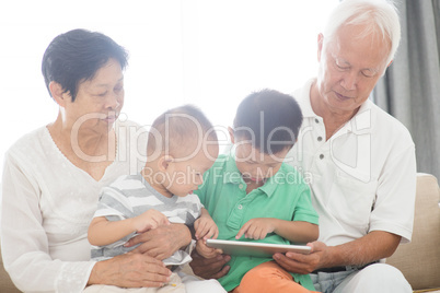 Grandparents and grandchildren using tablet pc