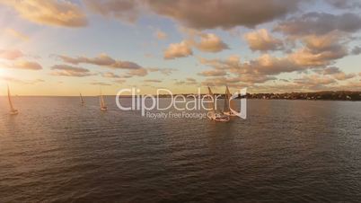 Aerial view of yachts with sails in the sea with a beautiful scenic sunset views. Yachts in the open sea