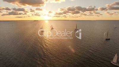Aerial view of yachts with sails in the sea with a beautiful scenic sunset views. Yachts in the open sea