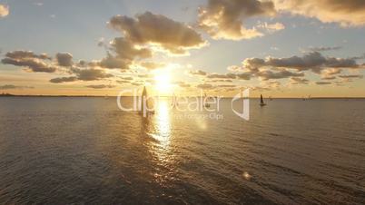 Aerial view of yachts with sails in the sea with a beautiful scenic sunset views. Yachts in the open sea