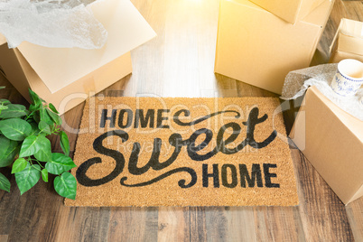 Home Sweet Home Welcome Mat and Moving Boxes on Hard Wood Floor