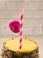 Fresh pineapple with a drinking straw
