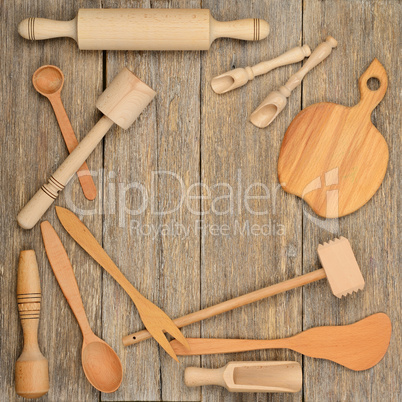 Kitchen wooden utensils (spoon, plate, fork, pestle) on a table