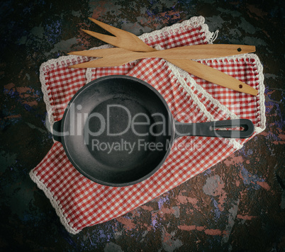 round empty black cast-iron frying pan on a red napkin