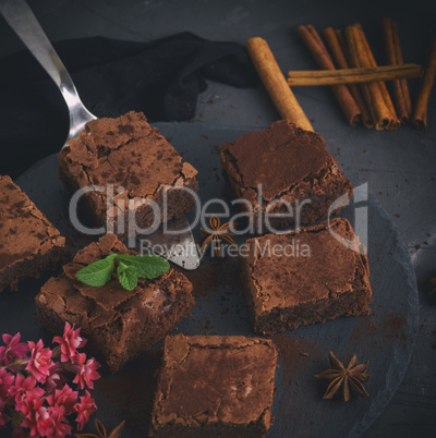 pieces of chocolate brownie on a black round graphite plate