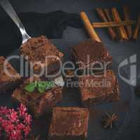 pieces of chocolate brownie on a black round graphite plate