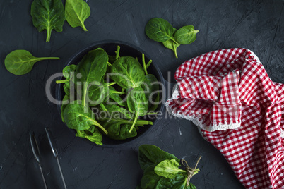 fresh green spinach in a round cast-iron frying pan