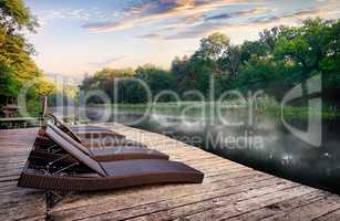 Chaise longues near river