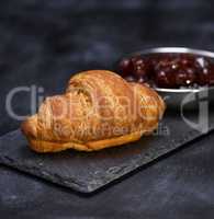 baked croissant on a black graphite background