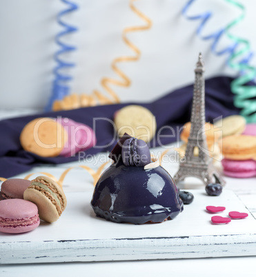 lilac round cake with macarons on a white wooden board,