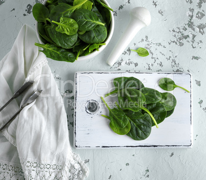 green spinach leaves on a white wooden board