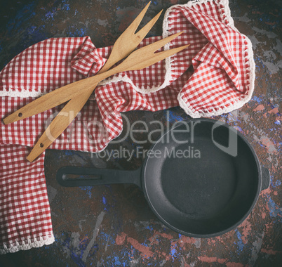 black cast-iron frying pan with a handle and two wooden forks